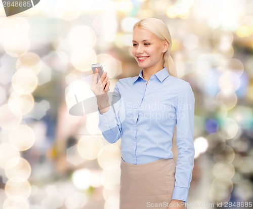 Image of young smiling businesswoman with smartphone