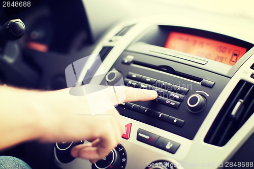 Image of man using car audio stereo system