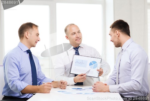 Image of smiling businessmen with papers in office