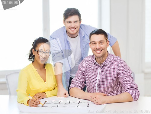 Image of three smiling architects working in office
