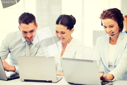 Image of group of people working with laptops in office