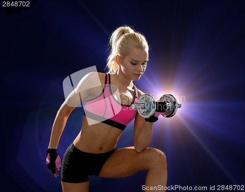 Image of young sporty woman with heavy steel dumbbell