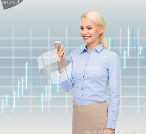 Image of young smiling businesswoman with smartphone