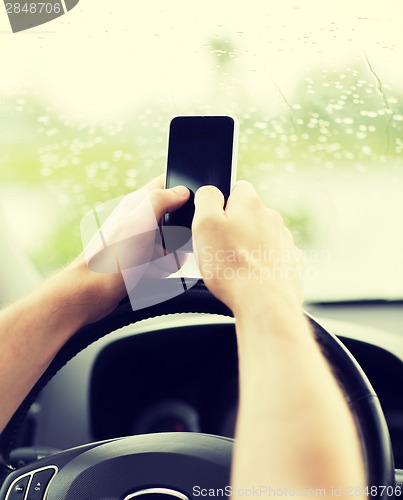 Image of man using phone while driving the car