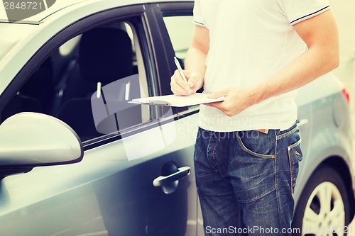 Image of man with car documents