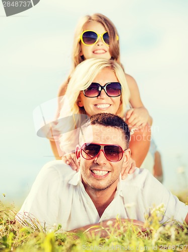 Image of happy family with blue sky and green grass