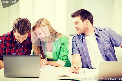 Image of students writing something at school