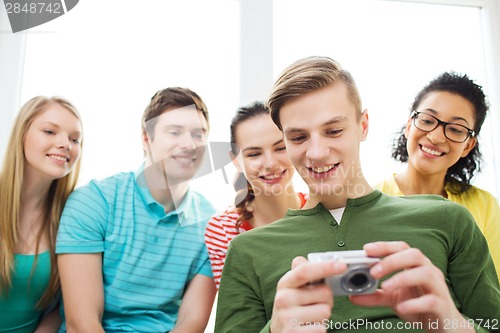 Image of smiling students with digital camera at school