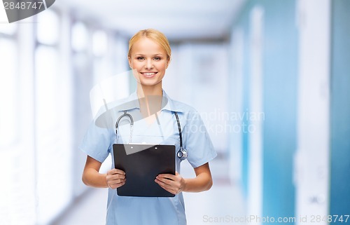 Image of smiling female doctor or nurse with clipboard