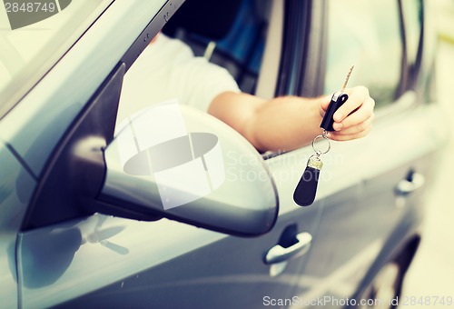 Image of man with car key outside