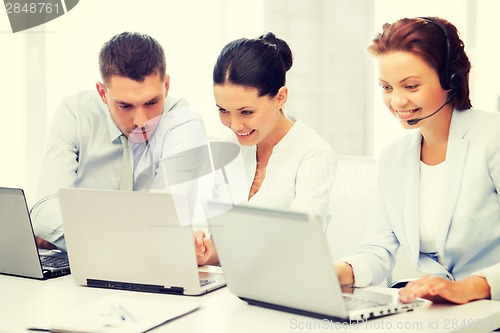 Image of group of people working with laptops in office