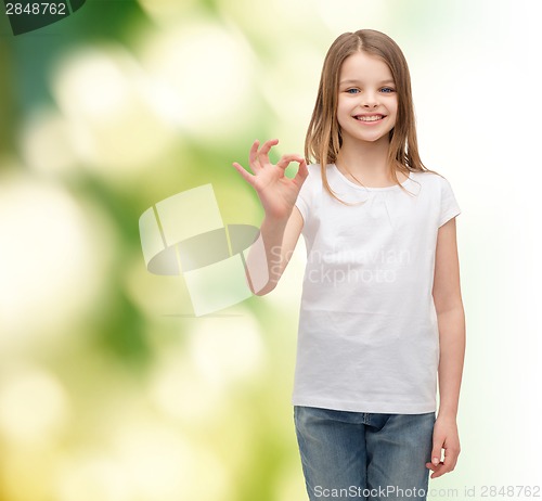 Image of little girl in white t-shirt showing ok gesture