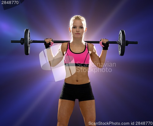 Image of sporty woman exercising with barbell