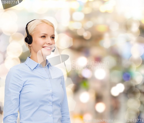 Image of friendly female helpline operator with headphones