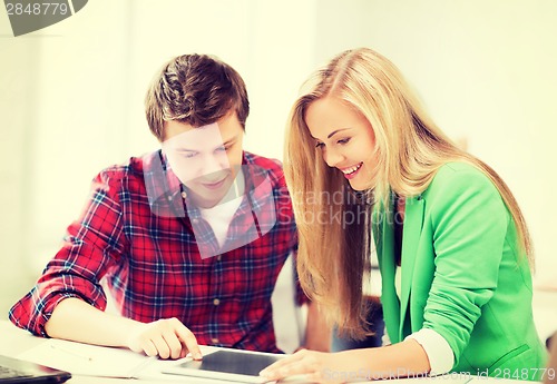 Image of students looking at tablet pc at school