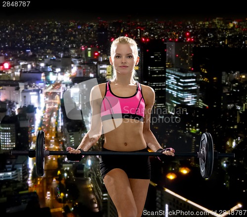 Image of sporty woman exercising with barbell