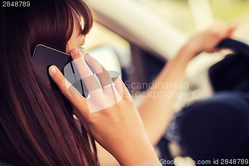 Image of woman using phone while driving the car