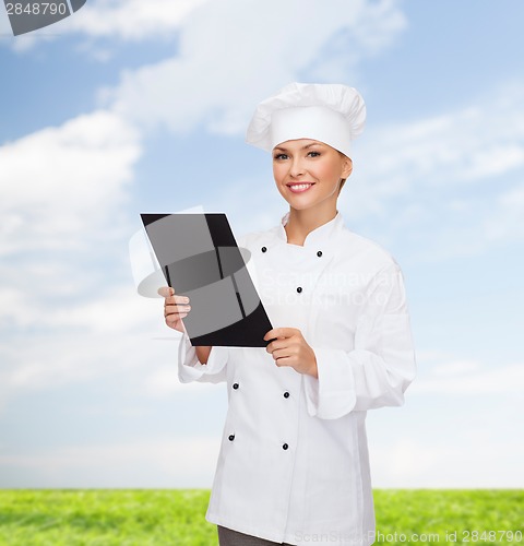 Image of smiling female chef with black blank paper