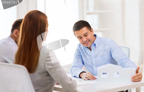 Image of couple looking at model of their house at office