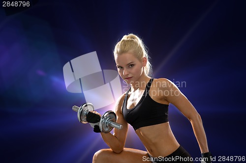 Image of young sporty woman with heavy steel dumbbell