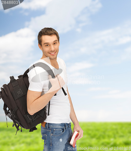 Image of travelling student with backpack and book