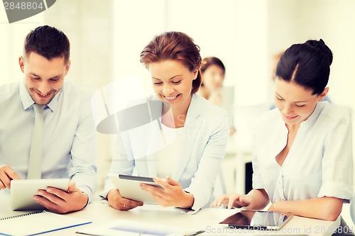 Image of business team working with tablet pcs in office