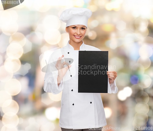 Image of smiling female chef with black blank paper