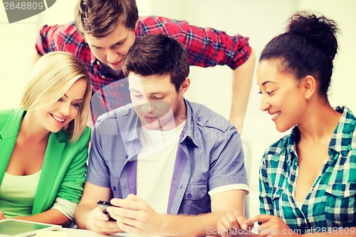 Image of students looking at smartphone at school