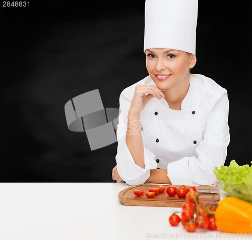 Image of smiling female chef with vegetables