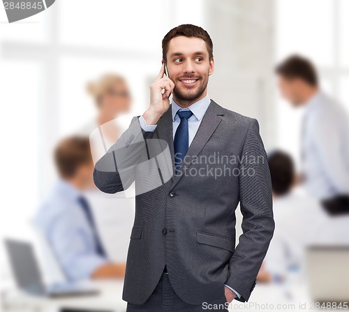 Image of young smiling businessman with smartphone