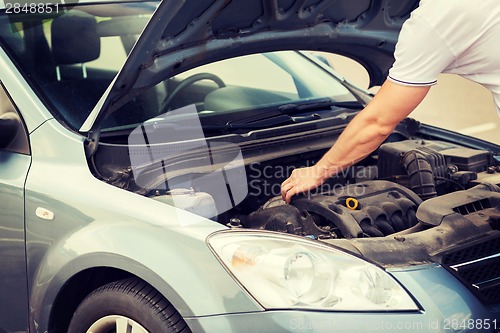 Image of man opening car bonnet