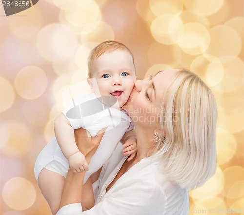 Image of happy mother kissing smiling baby