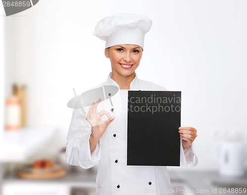 Image of smiling female chef with black blank paper