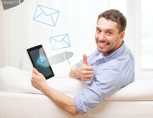 Image of smiling man working with tablet pc at home