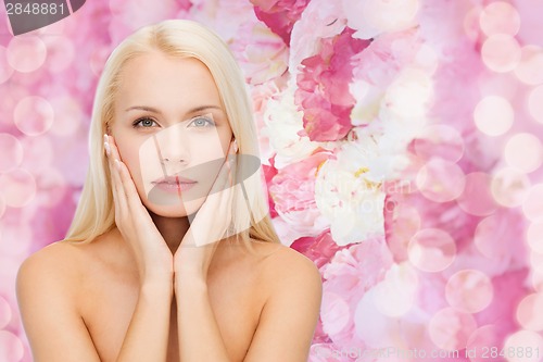 Image of beautiful woman touching her face skin