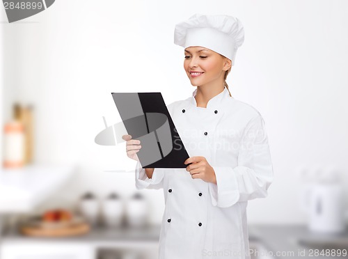 Image of smiling female chef with black blank paper