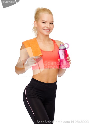 Image of smiling sporty woman with water bottle and towel