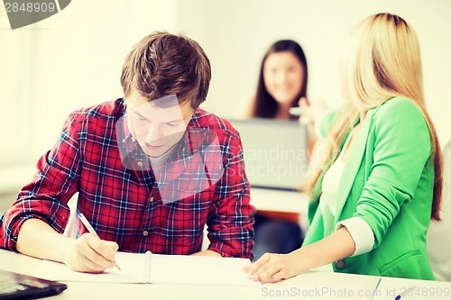 Image of students writing something at school