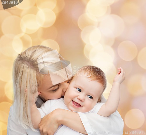 Image of happy mother kissing smiling baby