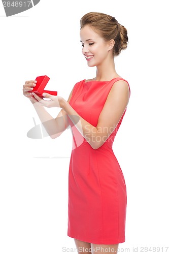 Image of smiling young woman in red dress with gift box