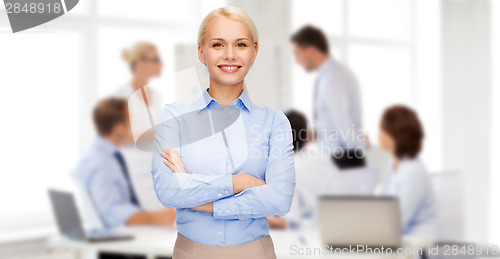 Image of young smiling businesswoman with crossed arms