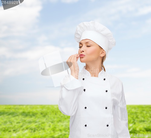 Image of smiling female chef showing delicious sign