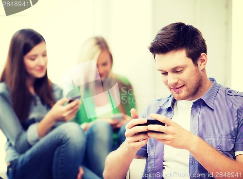 Image of students looking into devices at school