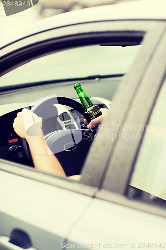 Image of man drinking alcohol while driving the car