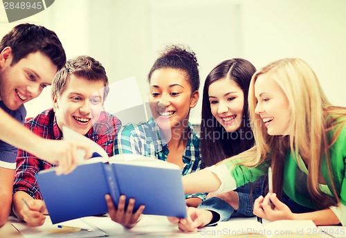 Image of students reading book at school