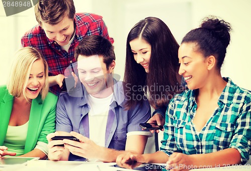Image of students looking at smartphone at school