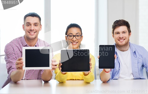 Image of smiling colleagues showing tablet pc blank screen