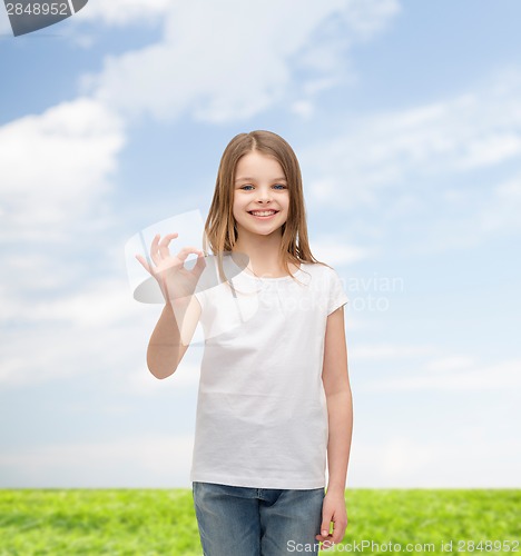 Image of little girl in white t-shirt showing ok gesture