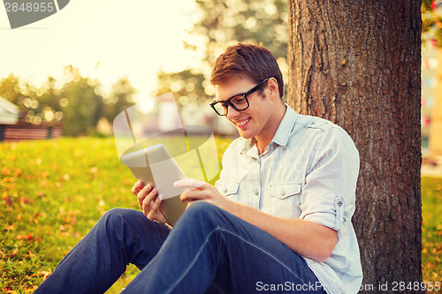 Image of smiling male student in eyeglasses with tablet pc