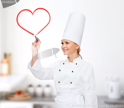 Image of smiling female chef writing something on air